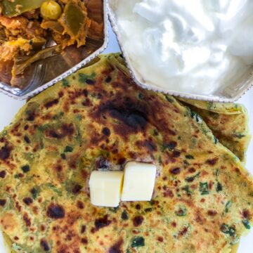 Palak parantha with butter pickle and bowl of yogurt