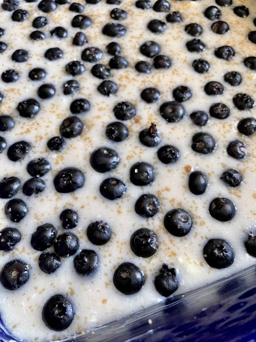 Cobbler batter with blueberries and coarse sugar in a baking dish ready to be baked