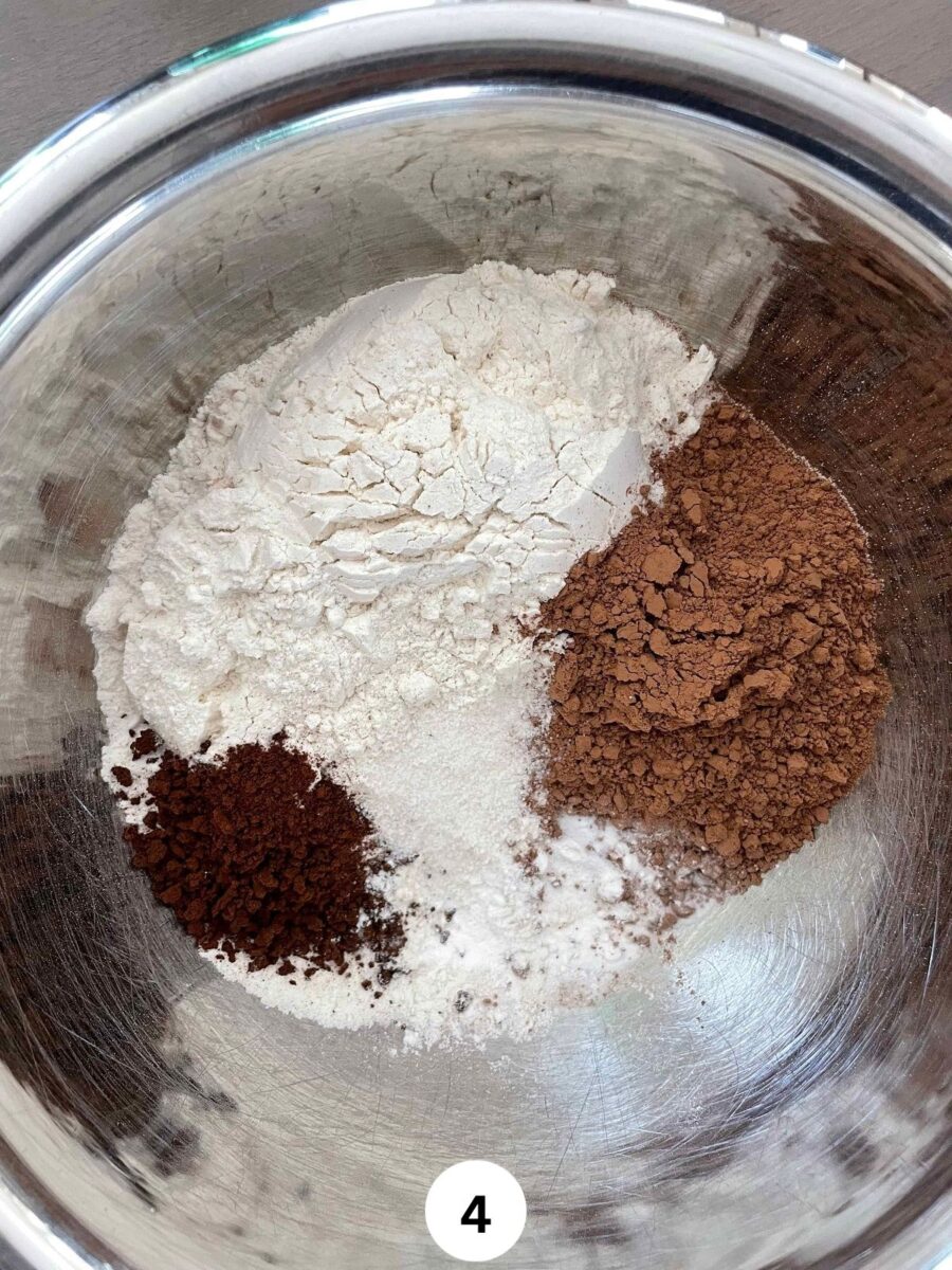 Dry ingredients - flour, coffee granules, cocoa powder, baking powder, baking soda, and salt in a steel mixing bowl.