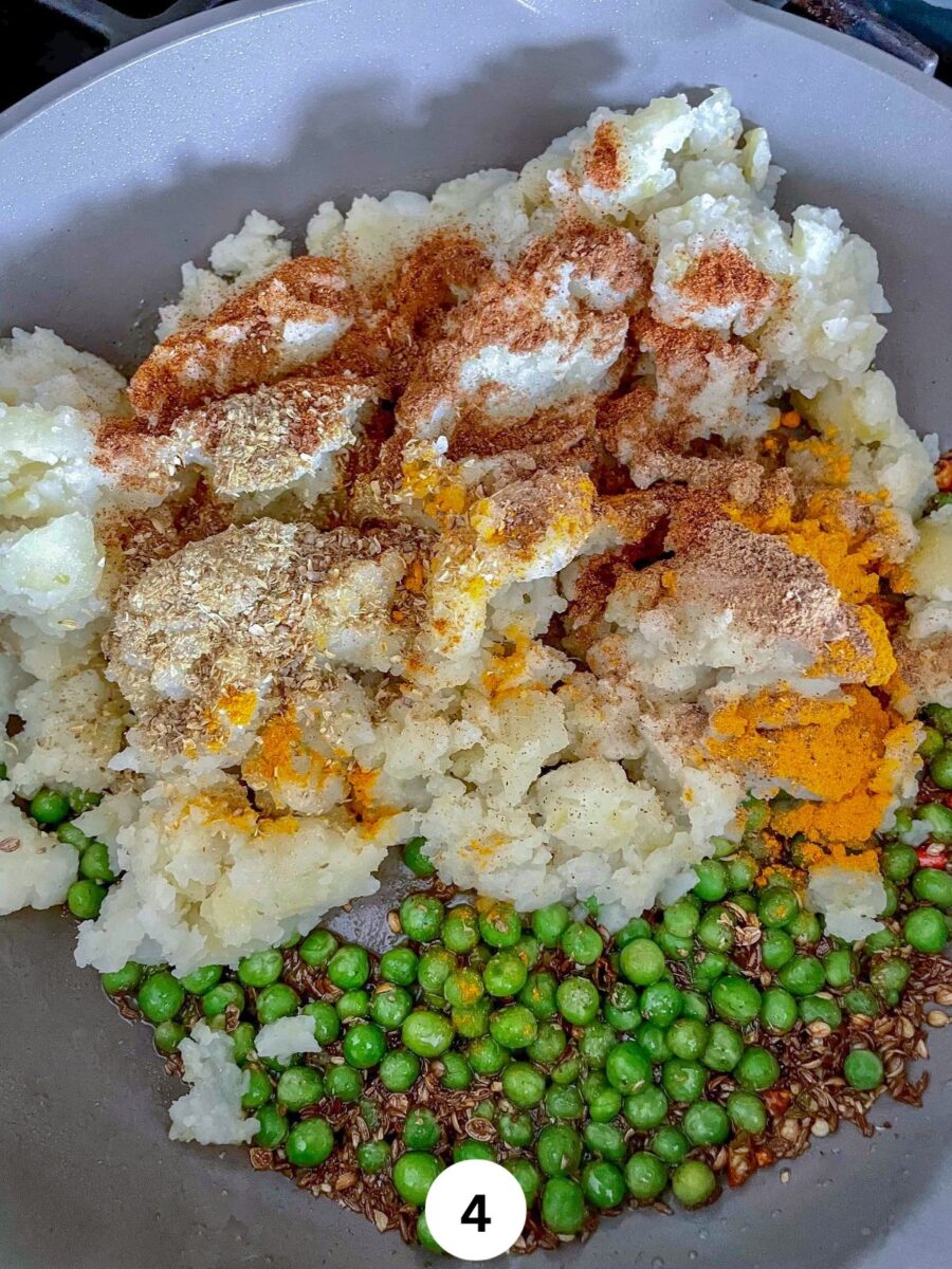 Boiled, mashed potatoes and green peas in a non stick pan with spices.