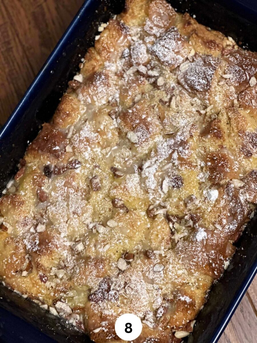 Indian bread pudding in a ceramic baking dish sprinkled with powder sugar and drizzled with sugar glaze.