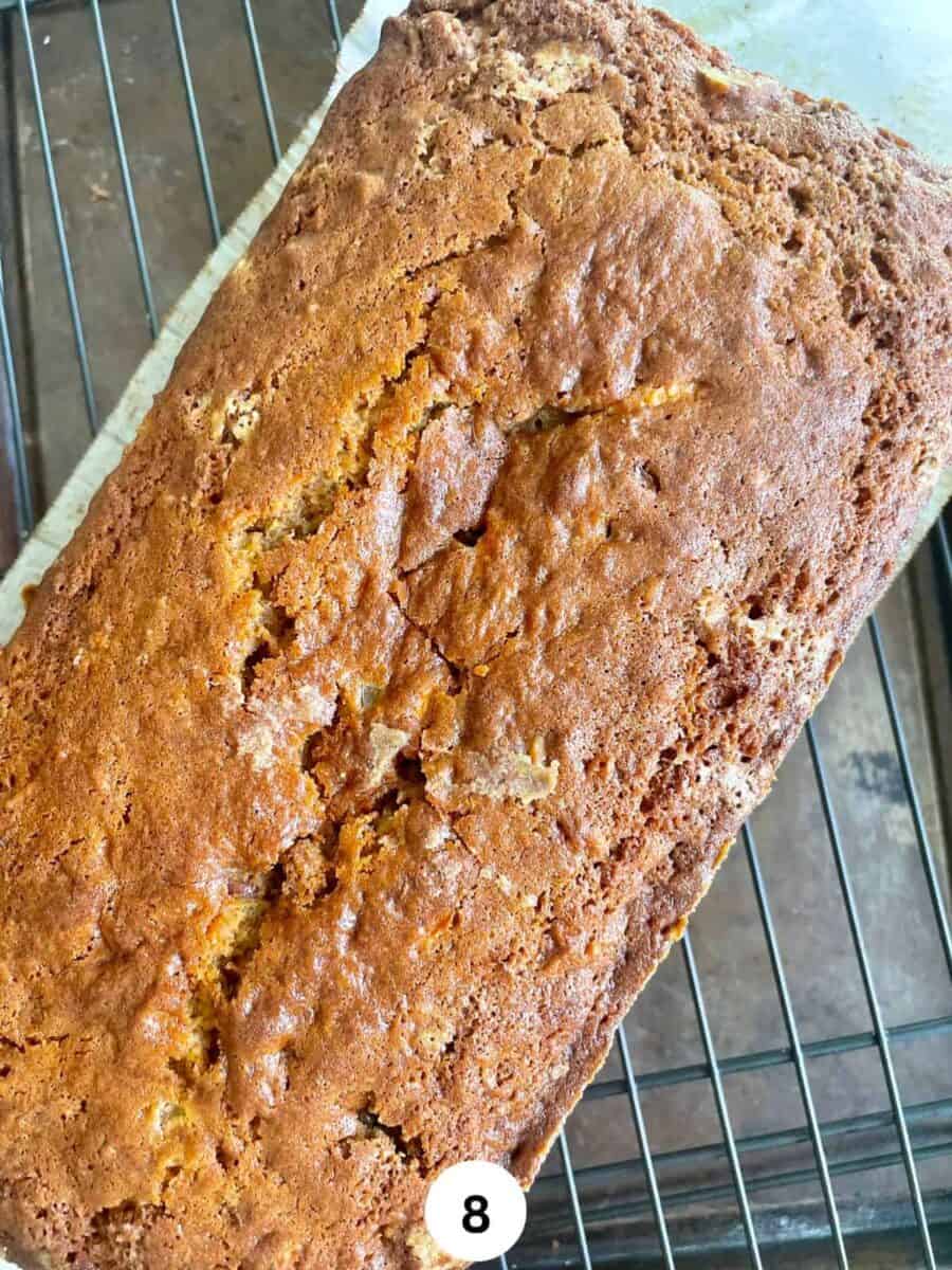 A carrot cake loaf on a black cooling rack.