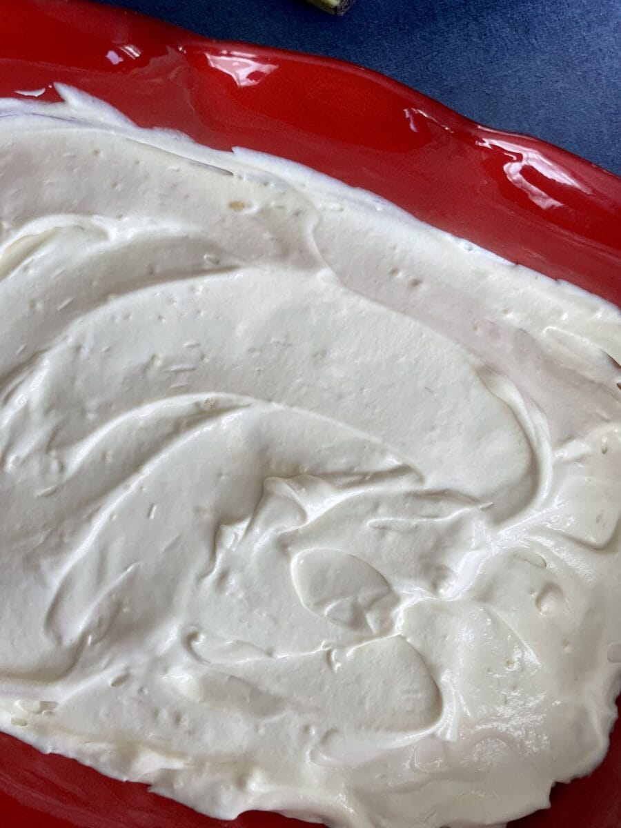 Vanilla pudding in a red ceramic dish.