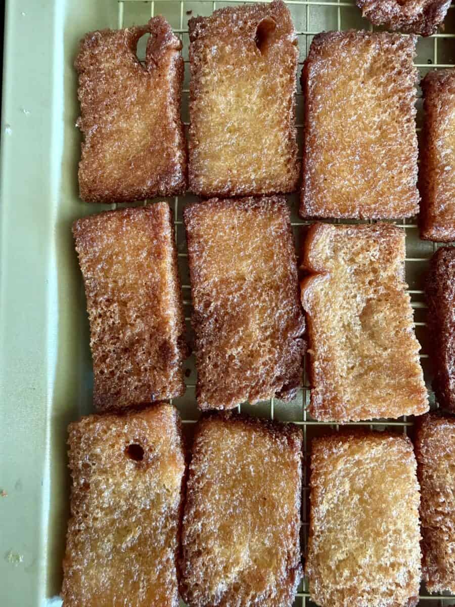 Golden fried bread pieces on a cooling rack.