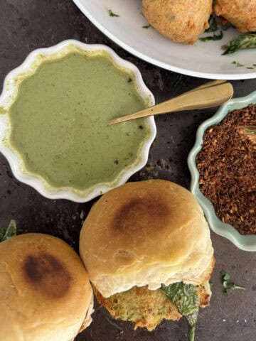 Mumbai vada pav served with green chutney and spicy powder, perfect for snacks or appetizers.