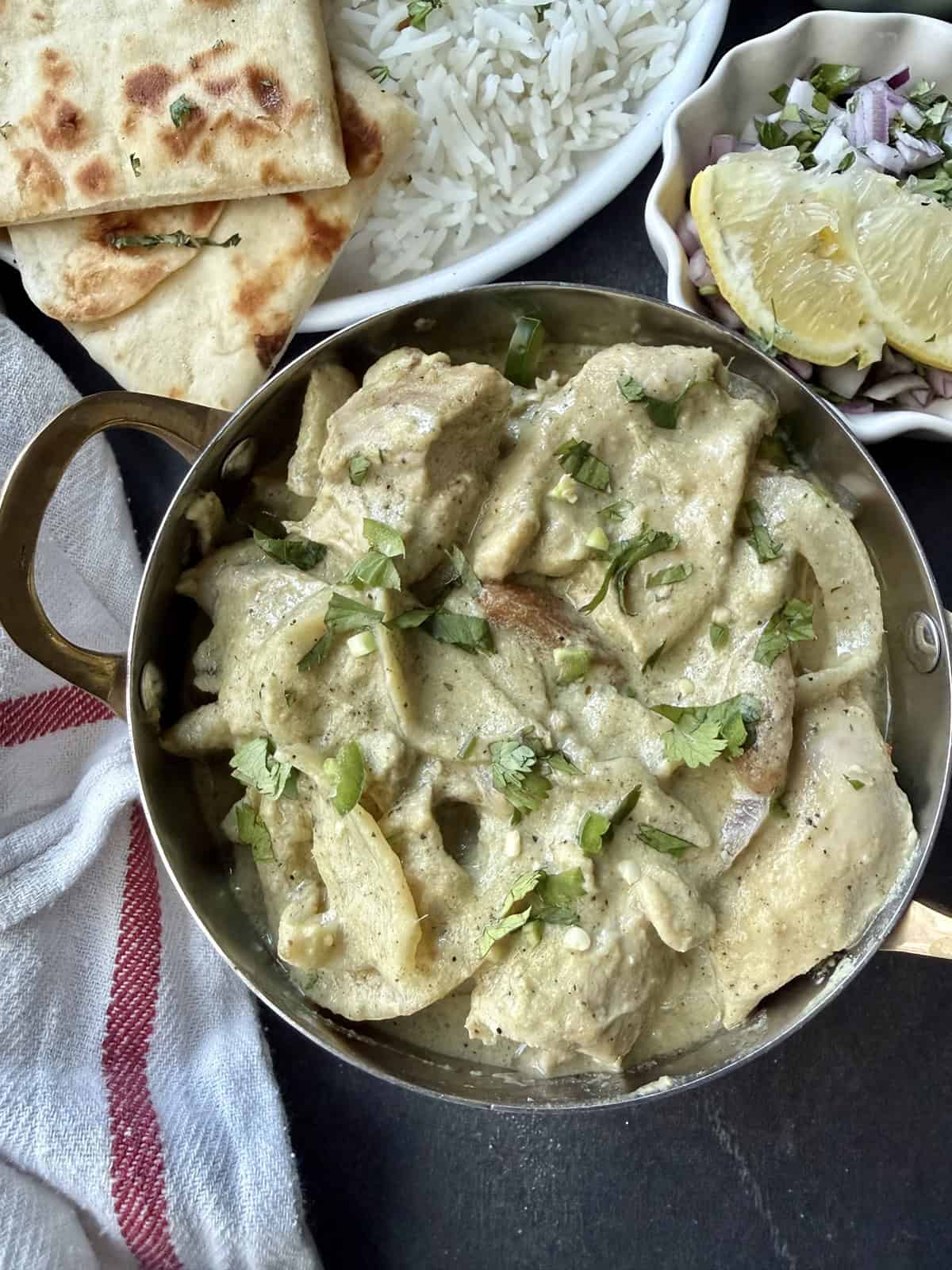 Afghani chicken without cashews with caramelized onions and blistered lemon and green chili slices.
