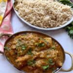 Easy weeknight punjabi chicken curry in a pot with rice on a white marble background.