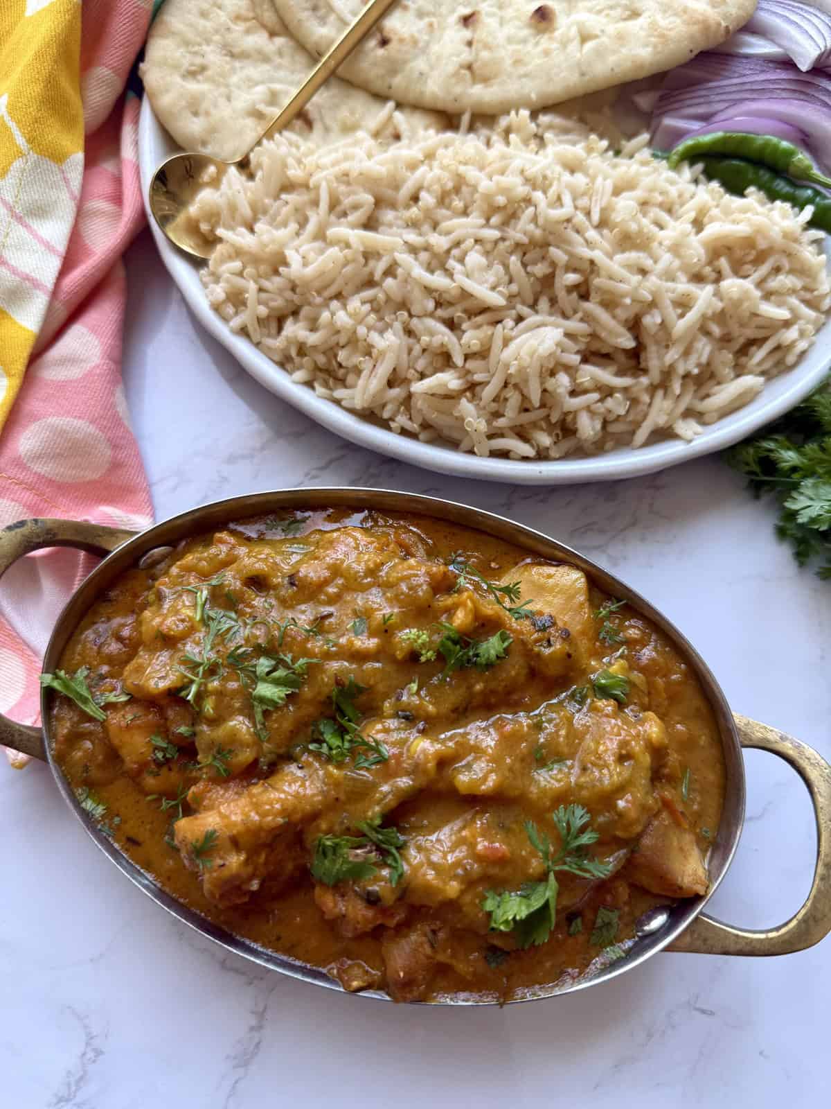 Easy weeknight punjabi chicken curry in a pot with rice on a white marble background.