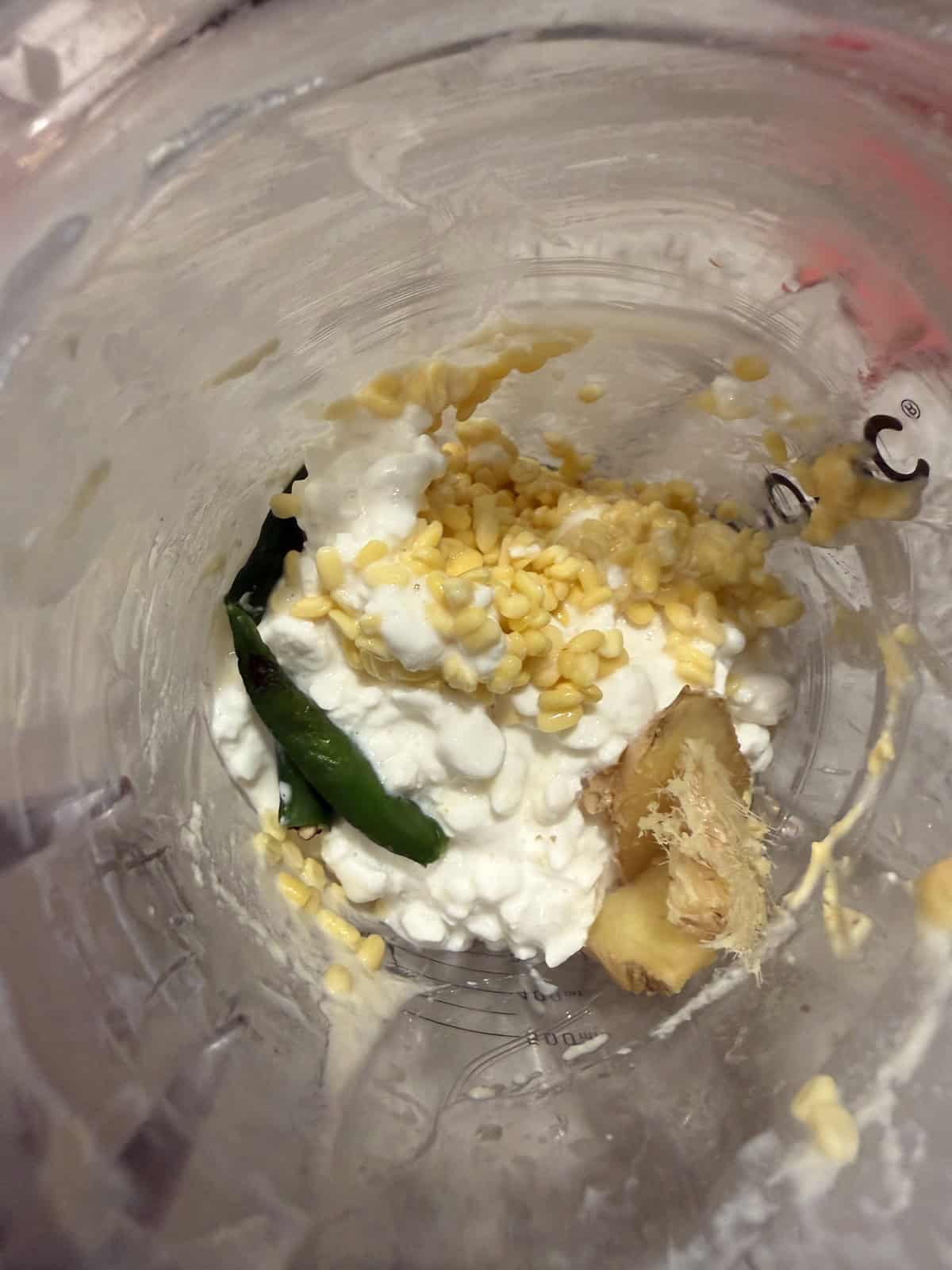 Moong dal, cottage cheese, ginger, and green chili in a blender jar.