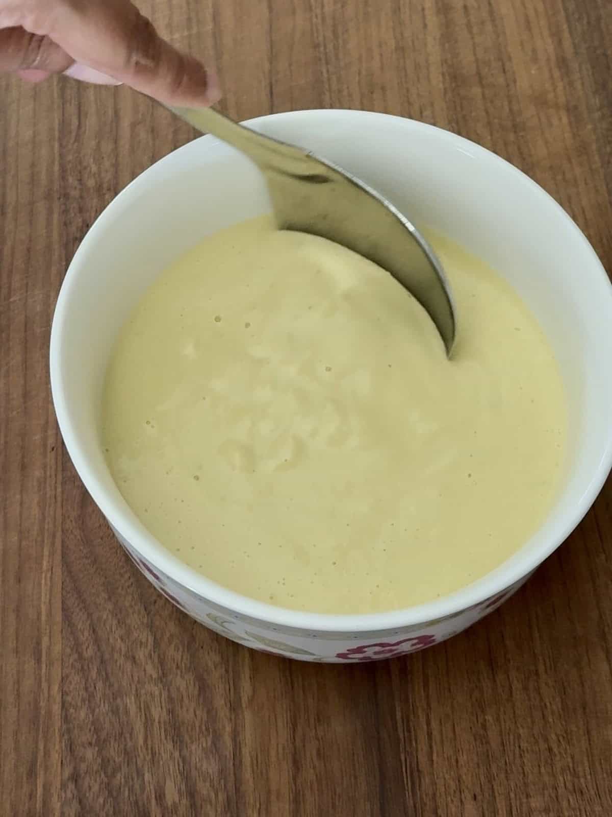 High protein moong dal cheela with cottage cheese batter in a white ceramic bowl.