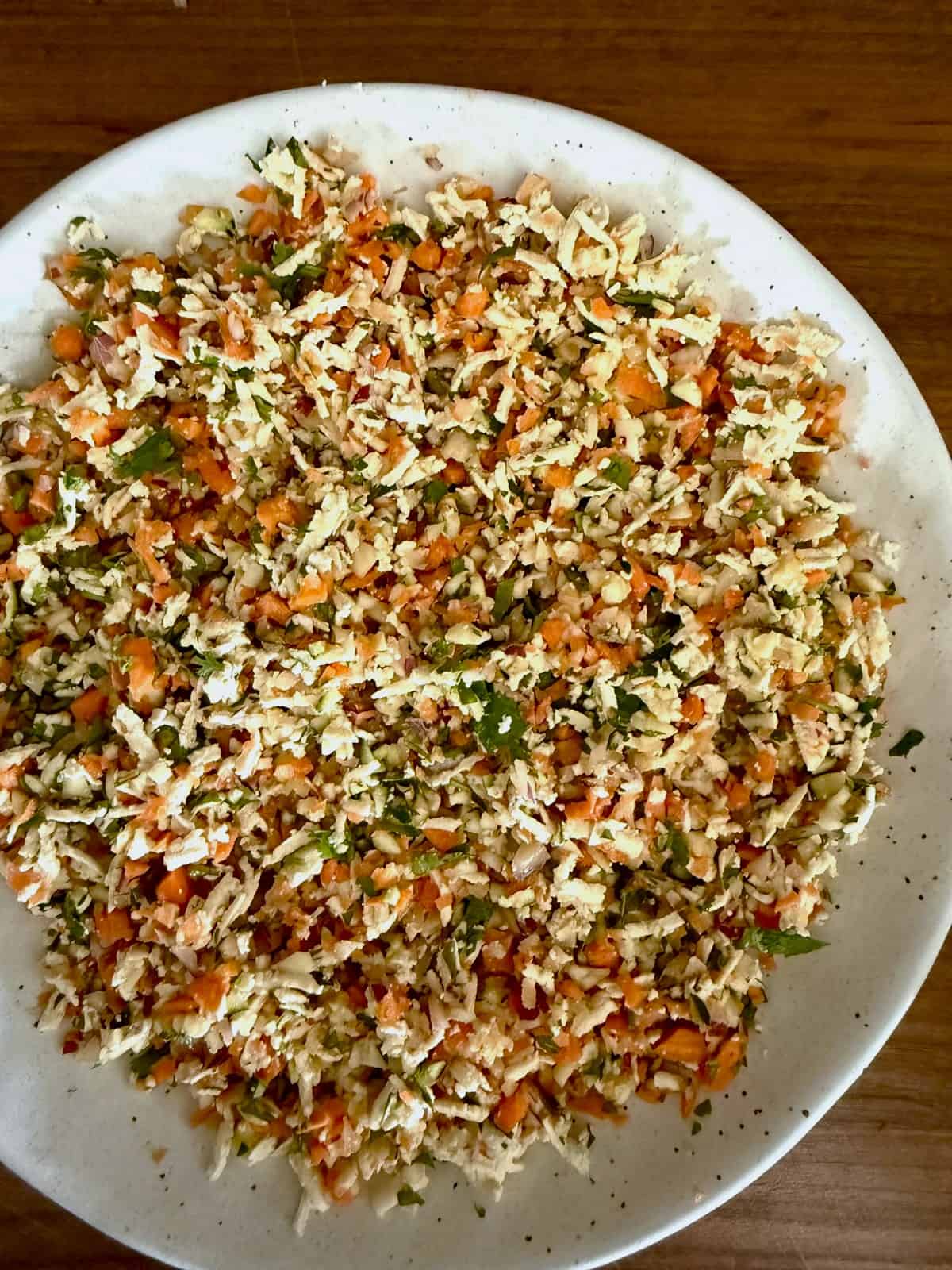 Shredded veggies and tofu in a white ceramic bowl.