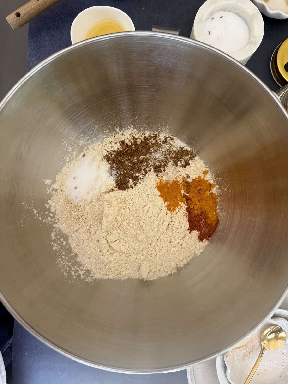 Flours and spices along with other ingredients of high protein tofu theplas in a stainless steel mixing bowl.