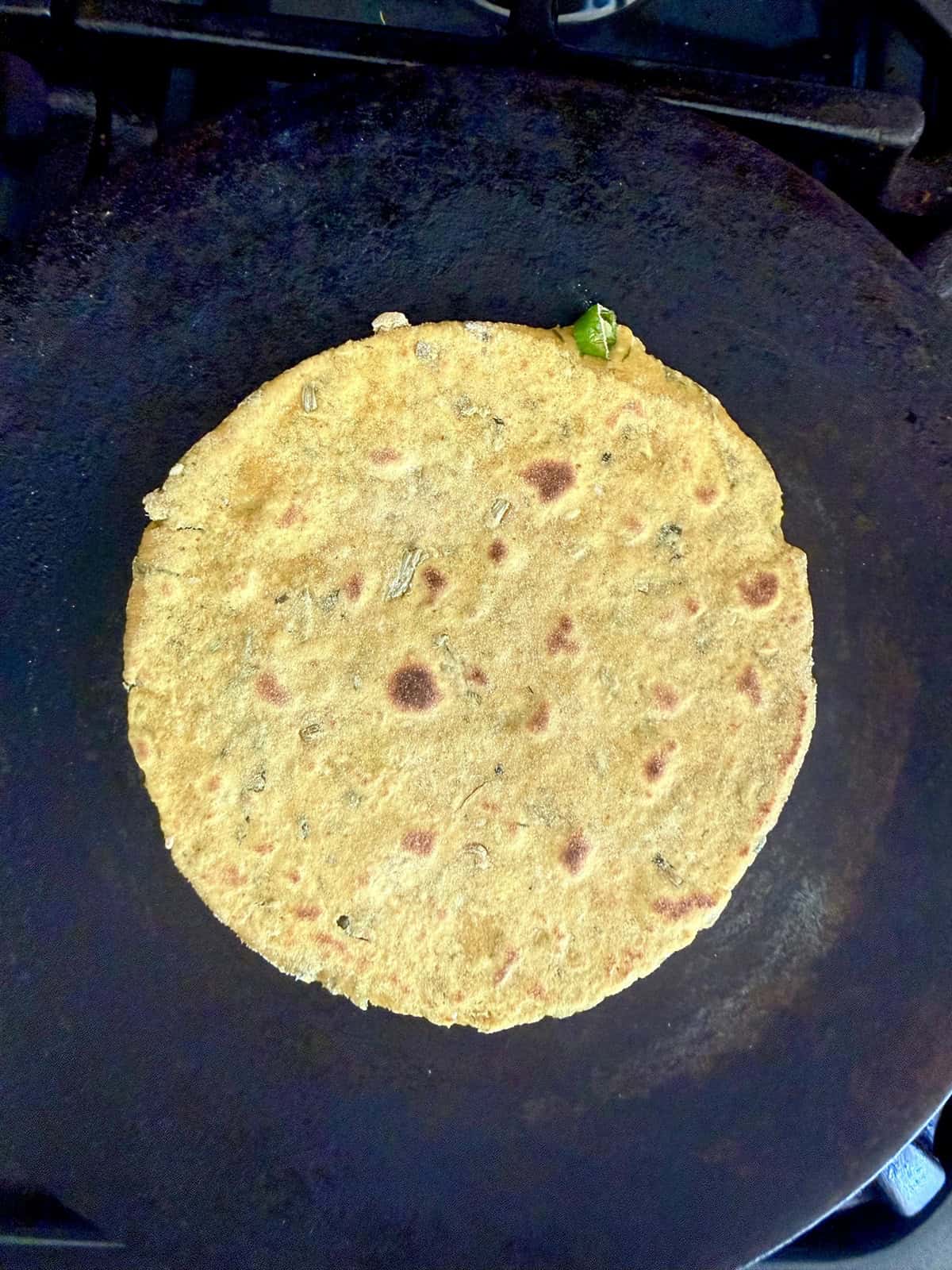 High protein tofu thepla cooking on a cast iron skillet.