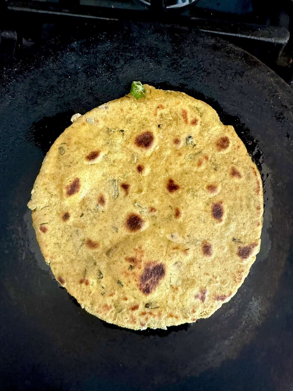 High protein tofu thepla cooking on a cast iron skillet.