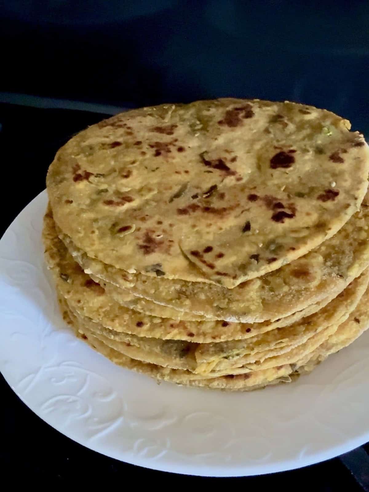 A stack of high protein tofu theplas on a white ceramic plate.