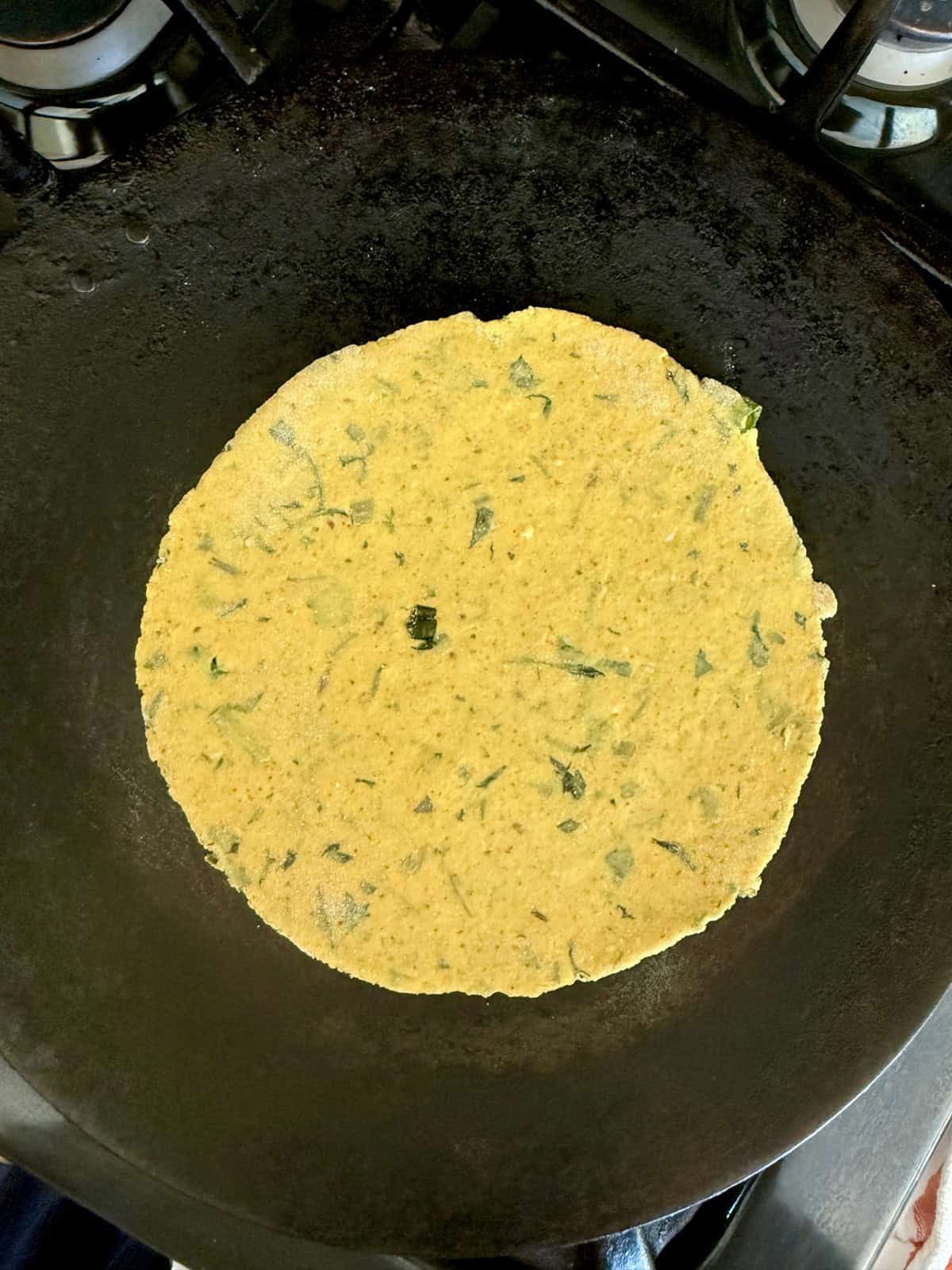 High protein tofu thepla cooking on a cast iron skillet.
