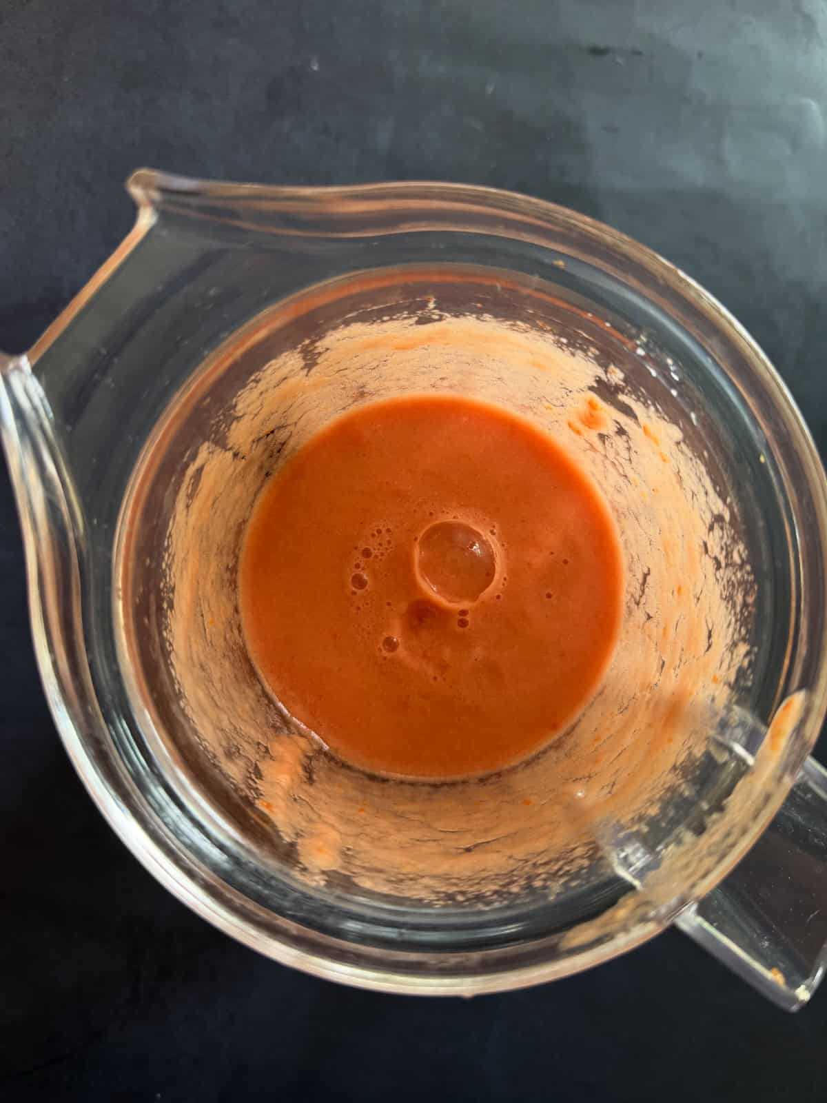 Blended onion tomato ginger garlic an dgreen chili paste in a blender jar.