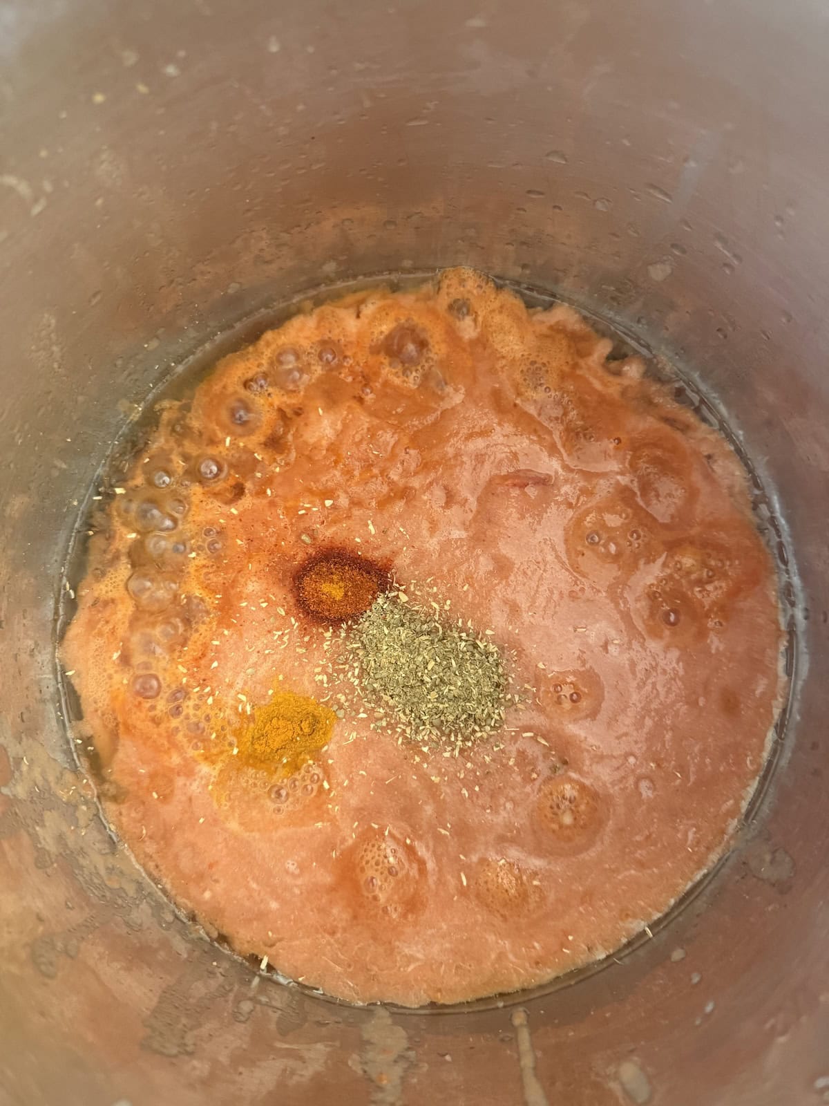 Tomoato onion masala with spice powders in the stainless steel insert of the Instant Pot.