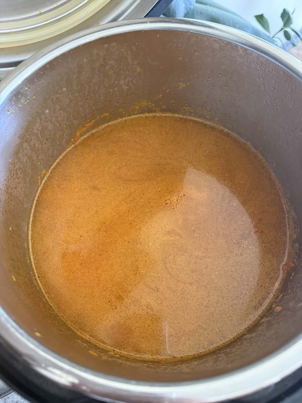 Indian spiced broth in hot oil in the stainless steel insert of the Instant Pot.