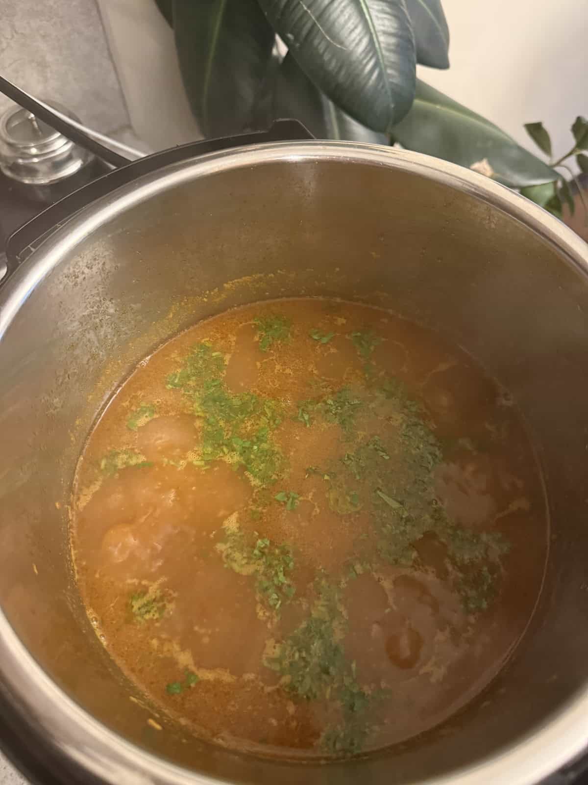 Cooked kala chana curry garnished with chopped cilantro in the stainless steel insert of the Instant Pot.