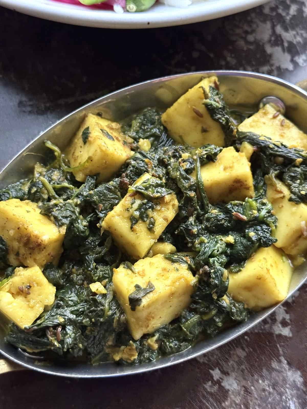Delicious palak paneer curry served in a traditional Indian dish.