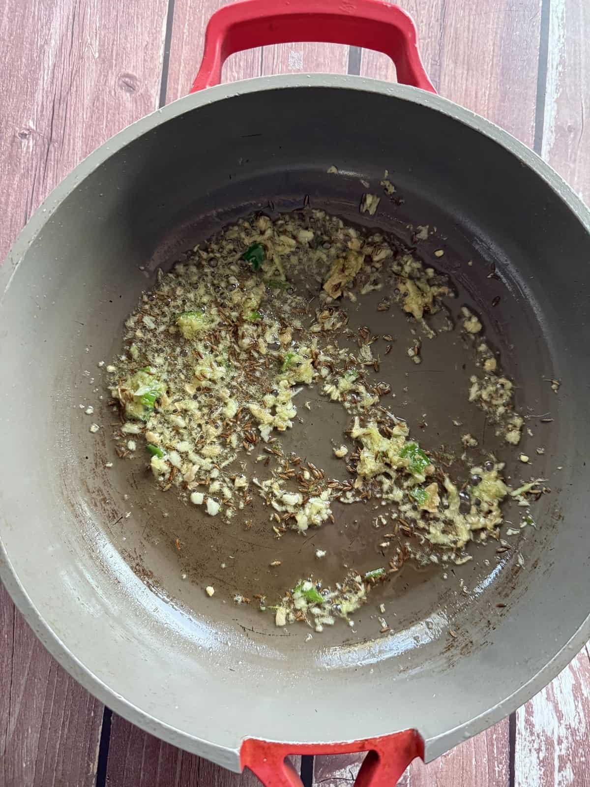 Ginger garlic and green chili paste being sautéed in a non-stick pan.